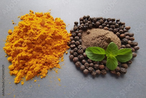 Turmeric powder (curcuma), black pepper corns and black pepper powder. Black pepper and turmeric can offer the potential health benefits individually or together. photo