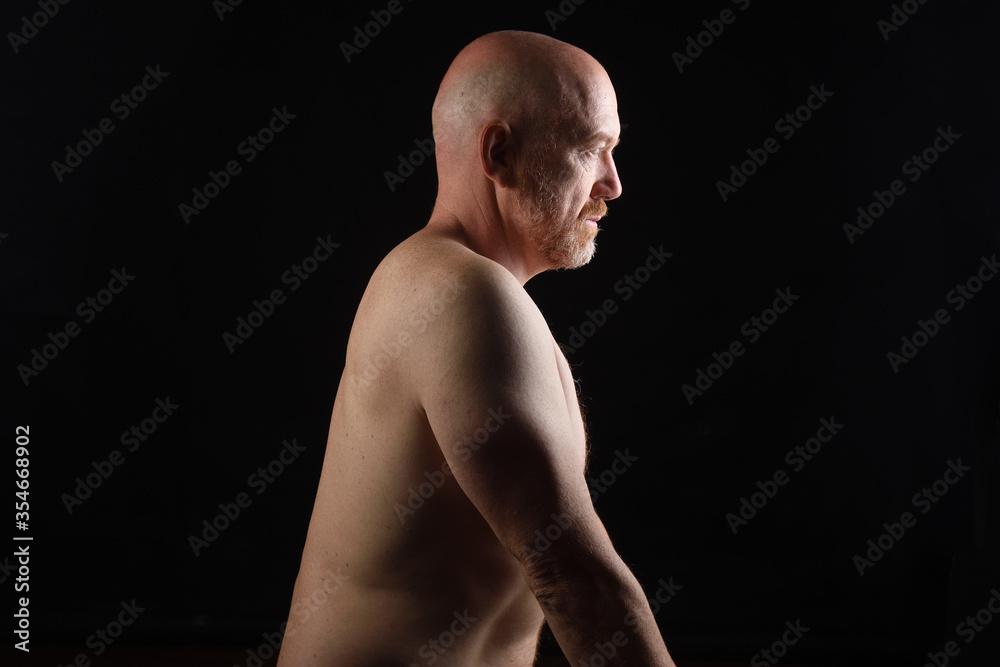 dark portrait of a shirtless man on black background dark portrait of a shirtless man on black background