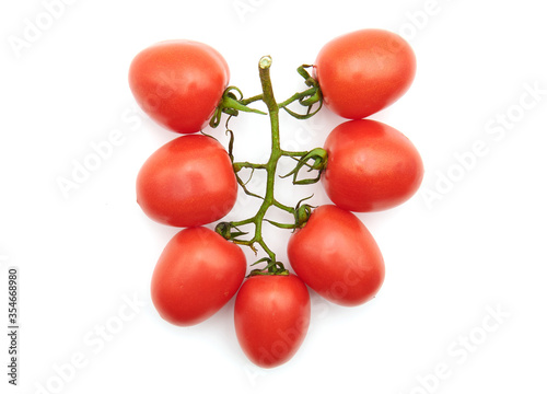 Organic grape tomatoes bunch symmetrically shaped as a necklace isolated on white, seven tomatoes. Narrow focus image. Red, perfumed bunch, rich in antioxidant beneficial molecules and vitamins.