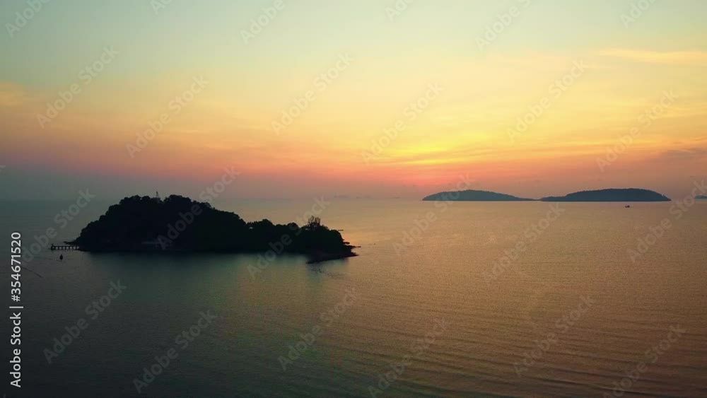 Aerial view of a beautiful sunrise behind the mountains island over the ocean and flying smooth over the sea in the morning viewpoint nature landscape of Thailand Aerial view of a beautiful sunrise behind the mountains island over the ocean and flying smooth over the sea in the morning viewpoint nature landscape of Thailand