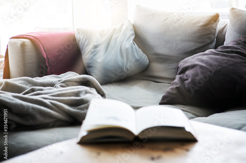 open book on table in living room with sunrays © wernerimages