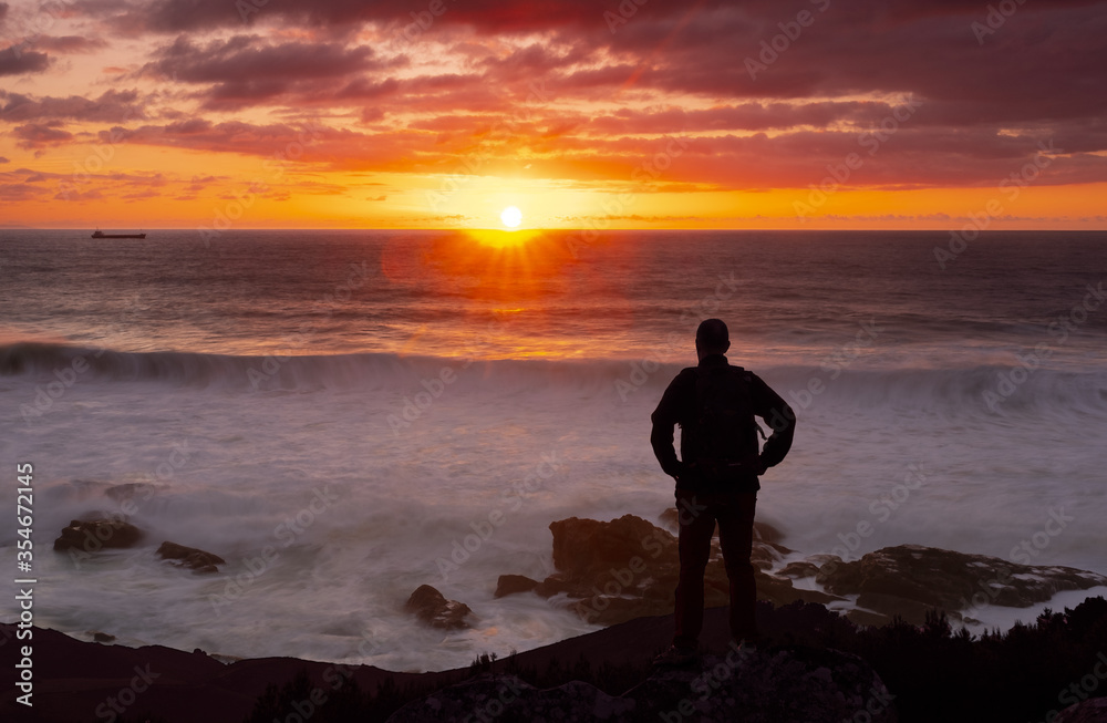 Fototapeta premium Man watching the sunset over the sea.