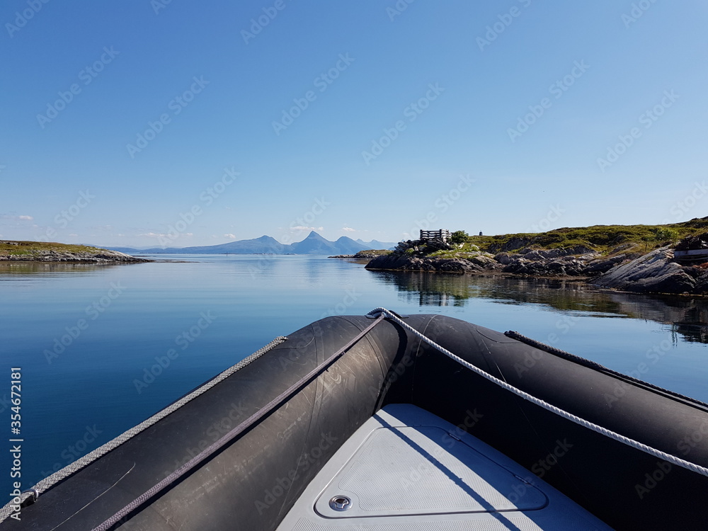 mirror calm ocean surface amongst small idyllic islands in nordland county archipelago