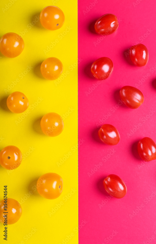 Red and yellow cherry tomatoes on the multicolored geometric background Red and yellow cherry tomatoes on the multicolored geometric background
