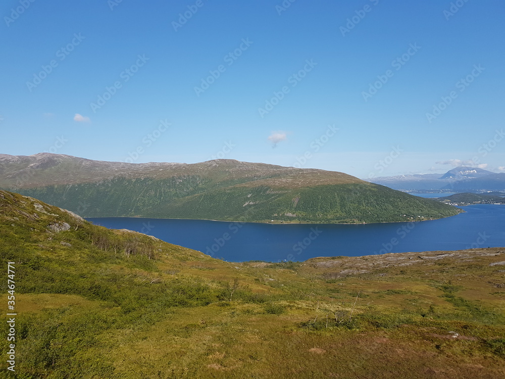 landscape with mountains and blue sky and ocean in northern norway on the whale island
