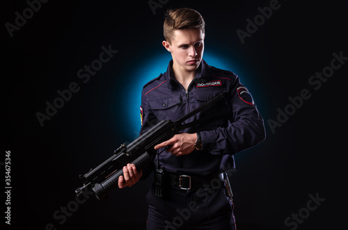 a guy in a police uniform with a short barreled automatic rifle with a telescopic sight takes aim. english translation "Police"