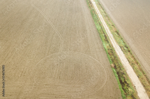 a field near a farm viewed from a drone