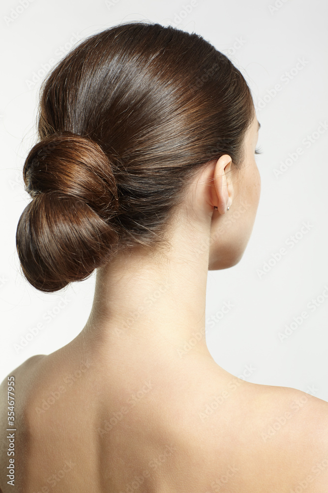 Back view portrait of beautiful young dark brunette woman on gray background. Back view portrait of beautiful young dark brunette woman on gray background.