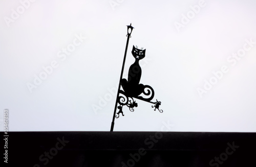 rickety vane on the roof in the shape of a black cat and mice