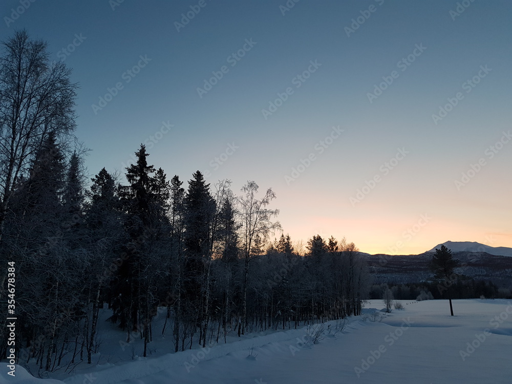 winter sunset in the mountains over snowy field winter sunset in the mountains over snowy field