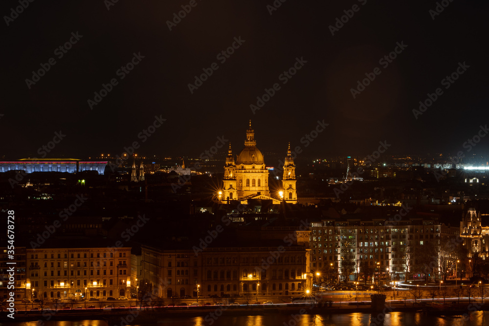 Night view of St. Stephenn's Basilica with lights on in Budapest night by Danube river
