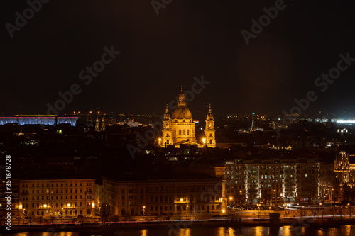 Night view of St. Stephenn s Basilica with lights on in Budapest night by Danube river