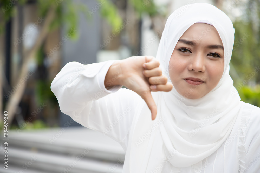 serious upset muslim woman showing thumb down gesture serious upset muslim woman showing thumb down gesture