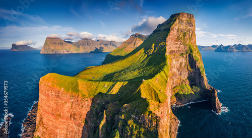 Gorgeous evening view from flying droneof Kallur Lighthouse, Kalsoy island. Spectacular summer scene of Faroe Islands, Denmark, Europe. Great seascape of Atlantic ocean. photo