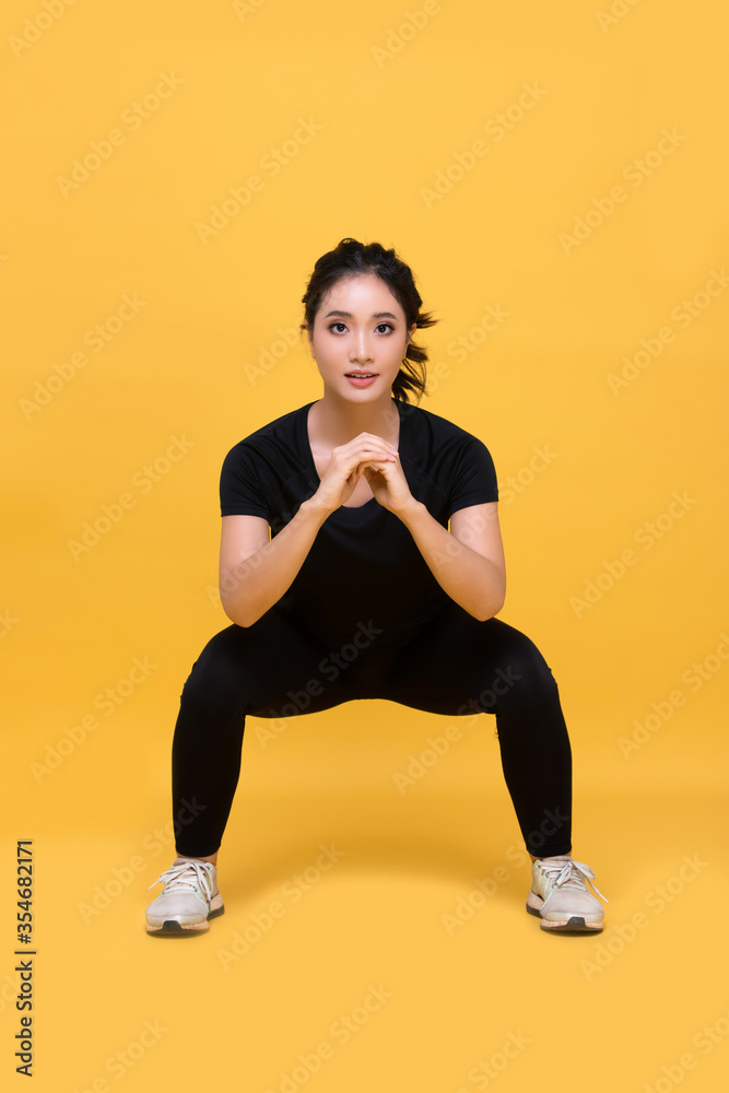 Smile happy Beautiful portrait young Asian woman stretching exercise workout on yellow background, fitness sport girl aerobic and healthy concept.