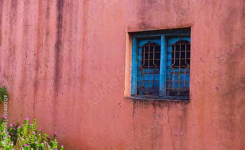 old wooden blue window with green shutters