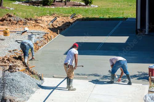 Unidentifiable Hispanic men working on a new concrete driveway photo