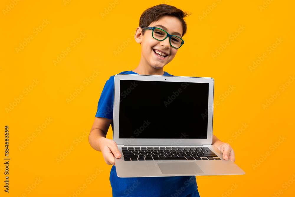 Computer Hand Boy caucasian boy holds laptop screen forward with mock up on yellow studio ...