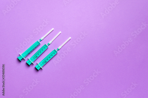 Top view of syringes in a row for medical injection on colorful background with copy space. Health and vaccination concept