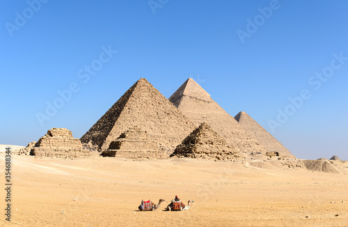 The great Pyramid complex of Giza with two camel caravan sitting in front of the Egyptian pyramids- Giza- Cairo -Egypt