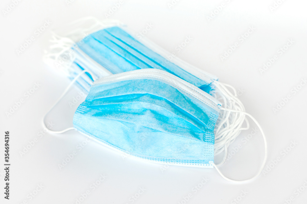 Blue protective simple surgical mask unfolded. Many simple anti viral disposable face masks group, heap, object isolated, product shot. Medical safety supplies bulk buying concept, nobody Blue protective simple surgical mask unfolded. Many simple anti viral disposable face masks group, heap, object isolated, product shot. Medical safety supplies bulk buying concept, nobody