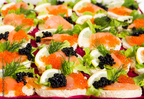 Small party sandwiches with caviar, salmon and lemon
