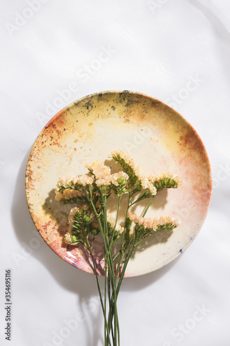 Top view of flowers in a plate in voile fabric background 