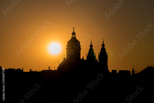 Neo-Baroque Basilica of Saint Nicholas silhouette at the sunset against orange sky with a sun setting behind in Amsterdam