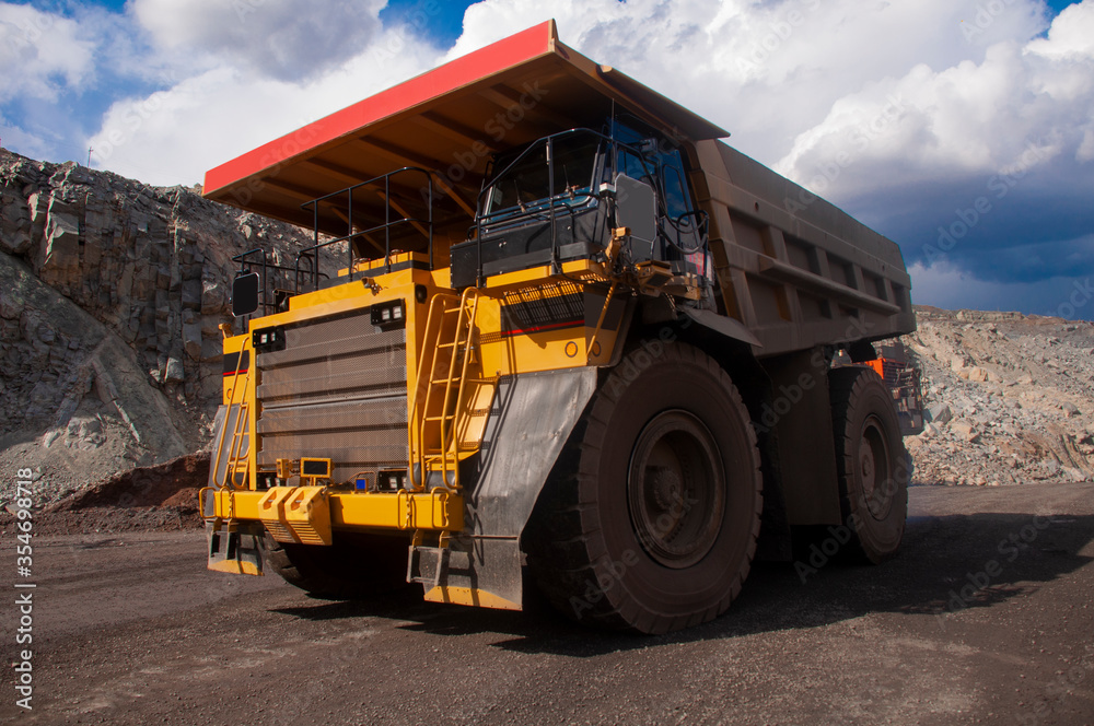 A large mining dump truck transports ore in a quarry A large mining dump truck transports ore in a quarry