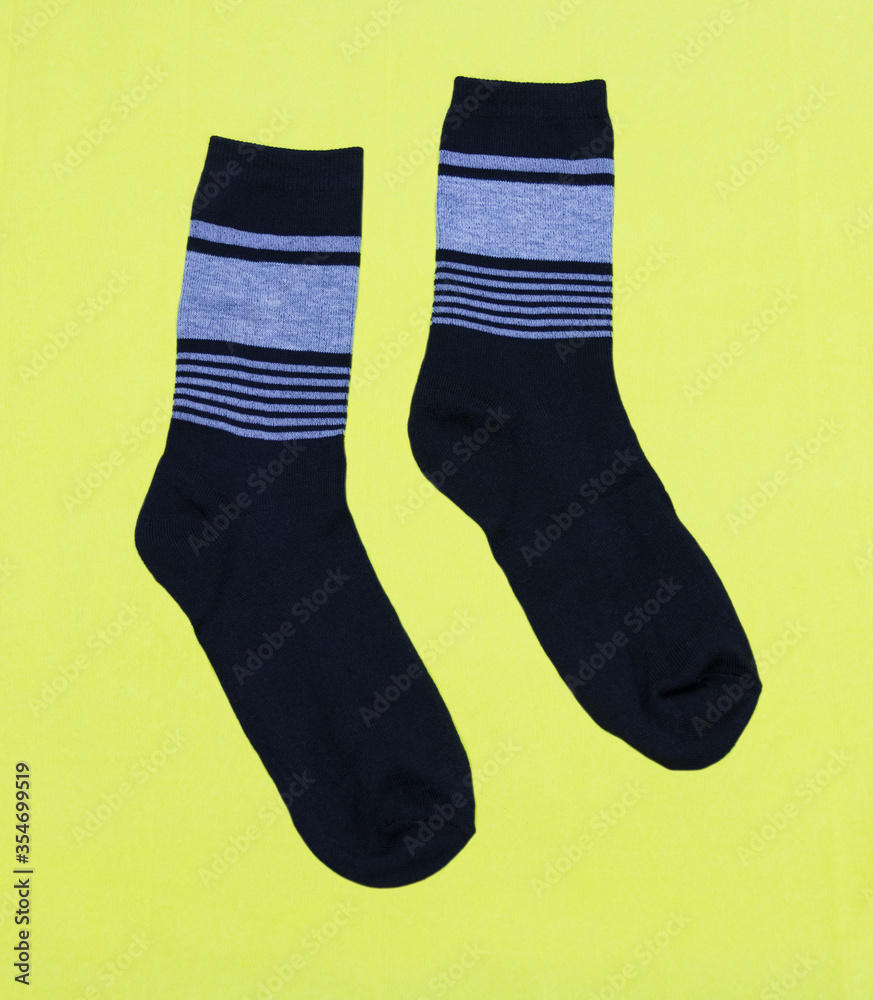 A pair of black men's socks on a yellow background A pair of black men's socks on a yellow background
