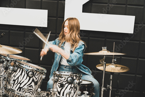 Creativity and music. Young beautiful girl plays the drums. Recording Studio. Musical equipment.