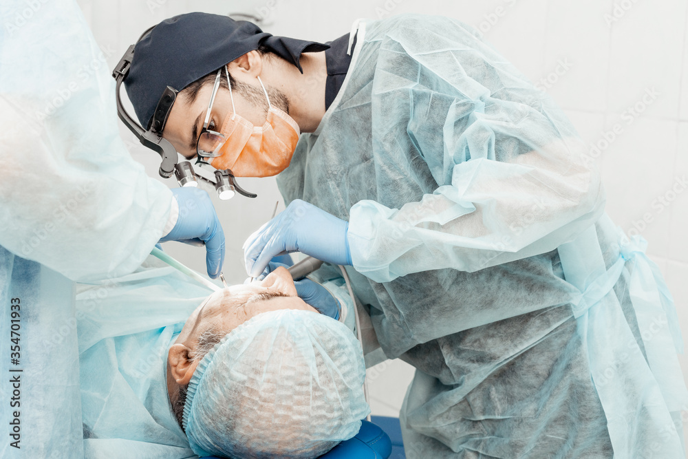 Dentists will perform an operation, implant placement. Real operation. Tooth extraction, implants. Professional uniform and equipment of a dentist. Healthcare Equipping a doctor’s workplace. Dentistry Dentists will perform an operation, implant placement. Real operation. Tooth extraction, implants. Professional uniform and equipment of a dentist. Healthcare Equipping a doctor’s workplace. Dentistry