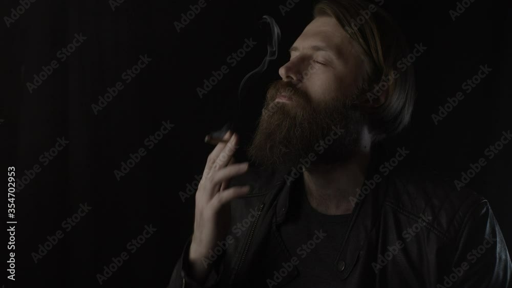 Smoking bearded man on black. Slow motion Smoking bearded man on black. Slow motion