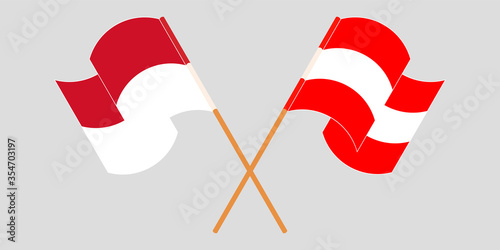 Crossed and waving flags of Indonesia and Austria