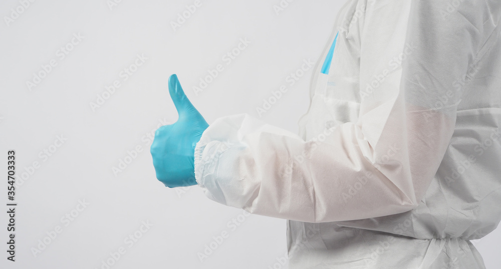 male asian doctor in PPE suite or Personal Protective Equipment and medical face mask to protect virus doing thumbs up hand sign on white background. male asian doctor in PPE suite or Personal Protective Equipment and medical face mask to protect virus doing thumbs up hand sign on white background.