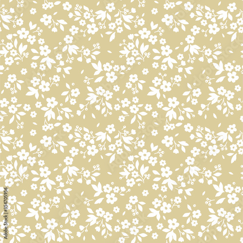Vintage floral background. Seamless vector pattern for design and fashion prints. Flowers pattern with small white flowers on a ivory background. Ditsy style.