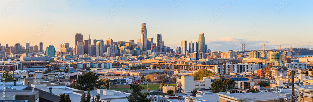 San Francisco skyline panorama just before sunset with city lights, the Bay Bridge and highway leading into the city