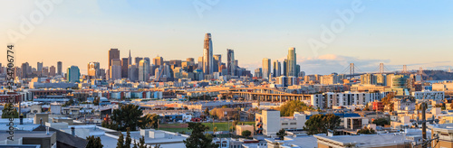 San Francisco skyline panorama just before sunset with city lights, the Bay Bridge and highway leading into the city