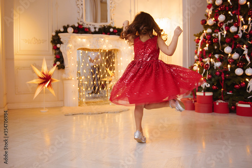One pretty little girl with blonde hair wearing red, sparkly Christmas dress