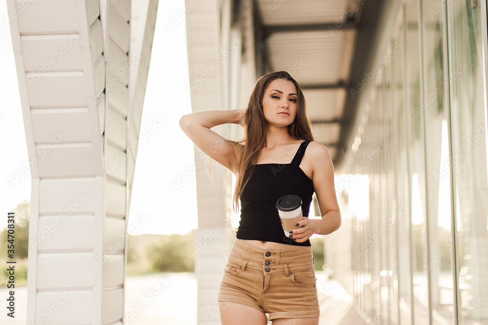 Beautiful young woman drink coffee and walking near the mall. Beautiful young woman drink coffee and walking near the mall.