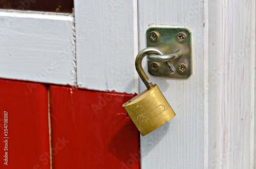 Padlock on a white and red painted wooden door photo