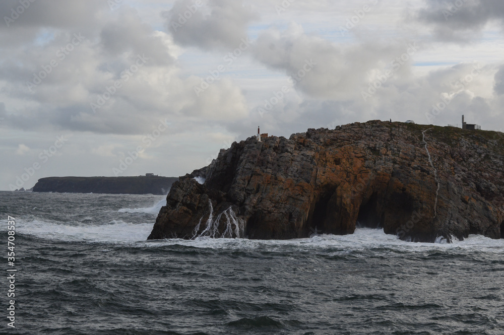 Rocky coastline with cliffs and waves. Sea waves that hit the cliffs.