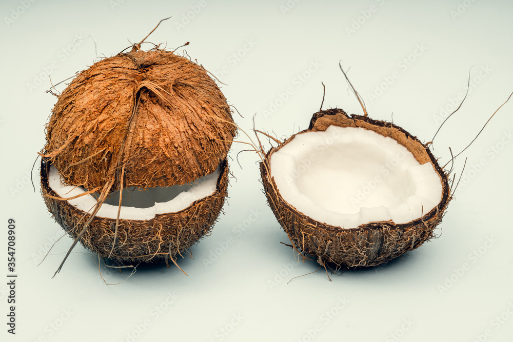 Parts of coconut on a colored background. Close up. Fresh ripe coconut broken into pieces. Parts of coconut on a colored background. Close up. Fresh ripe coconut broken into pieces.