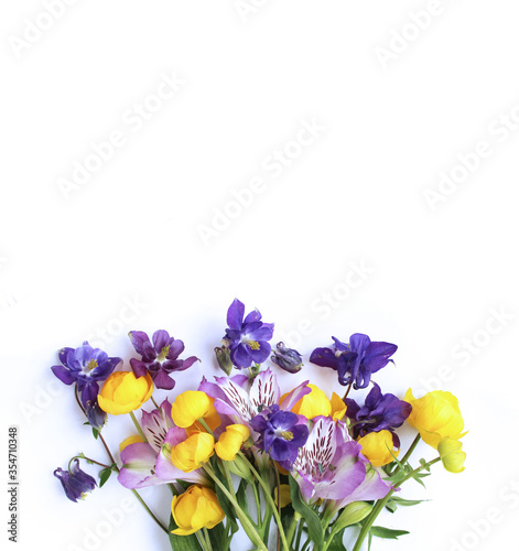 Bright spring flower arrangement. Lilac Alstroemeria and Aquilegia and yellow flowers of trolius europaeus on a white background. Bright light colors. Background for spring greeting cards, invitations photo