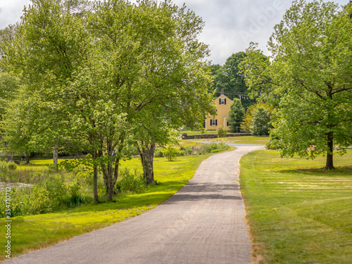 long road leading to yellow house in distance