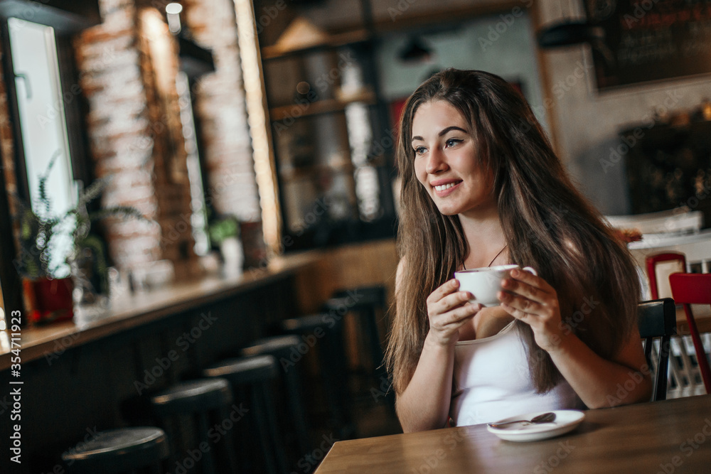 Beautiful woman drinking coffee sitting in a cafe.