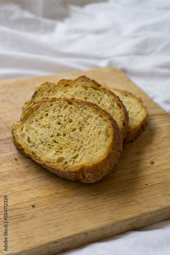 Corn bread slices over a wooden table on a white sheet background. Yellowish bread. Corn bread slices over a wooden table on a white sheet background. Yellowish bread.