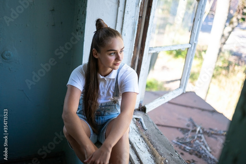 The girl is sad in the ruined house