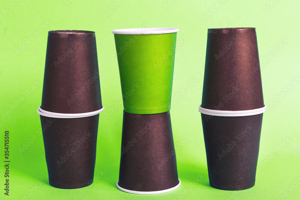Eco-friendly disposable brown and green paper cups on green background. Ecology concept. Eco-friendly disposable brown and green paper cups on green background. Ecology concept.