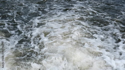 Rushing water in a mountain shallow river in slow motion video